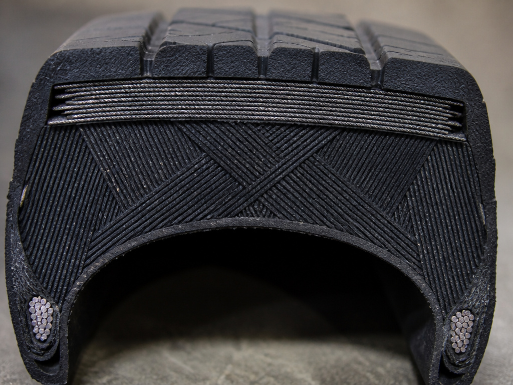Belted bias tire cross-section showing breaker belt and angled plies